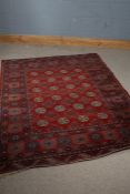 Middle Eastern style rug, the red ground with four rows of elephants foot pattern together with