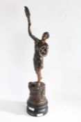 20th century French spelter figure depriving a man with tools holding a torch set on a black painted