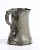 A mid-19th century pewter pint mug, Irish Of waisted form, with multi-reeded base, double scroll