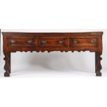 A George I oak and elm low dresser, circa 1720 Having a boarded top with applied moulded under-edge,