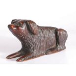A 19th century walnut model of a full-bodied long haired dog Recumbent, with raised head, carved out