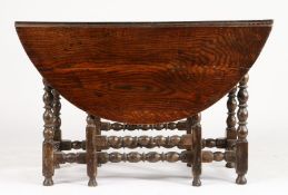 A Charles II oak gateleg dining table, circa 1680 Having an oval drop-leaf top, on ball and fillet-
