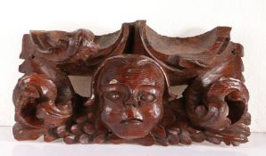 A striking 15th century pine roof boss, circa 1450 Carved with a 'cherub' mask wearing a skull-