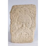 A carved gritstone 'Green Man', in the Romanesque Manner With leafy hair and exaggerated curled