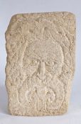 A carved gritstone 'Green Man', in the Romanesque Manner With leafy hair and exaggerated curled