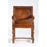 A small late 17th century oak panel-back open armchair, circa 1700 Having a plain back panel,