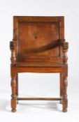 A small late 17th century oak panel-back open armchair, circa 1700 Having a plain back panel,