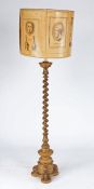 A giltwood standard lamp, having a spiral-turned pillar, on a circular triform base, with shade,
