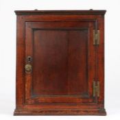 A small early George III joined oak mural cupboard, circa 1760 Having a single panelled door within