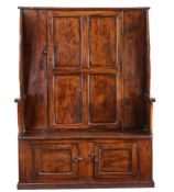 A George III elm 'bacon' settle, West Country, circa 1780 The back with a quadruple-panelled door,