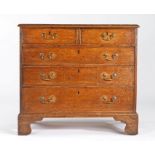 A George III oak chest of drawers, circa 1790 Of slender proportions, the rectangular boarded top