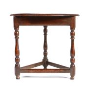 A small Queen Anne oak cricket-type table, circa 1710 The circular top above a moulded frieze, on