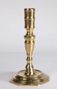 A late 17th century brass candlestick Having a tall socket, of waisted form with central fillet,