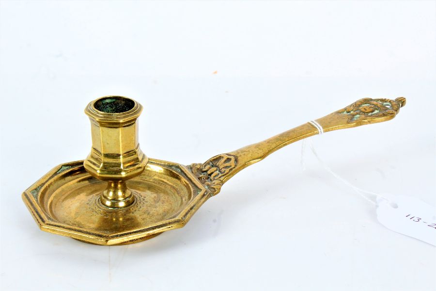 A cast brass chamberstick, French Having an octagonal socket and pan, mask terminal to handle,