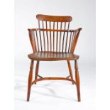 A George III fruitwood and elm comb-back Windsor armchair, circa 1800 The low back with nine