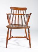 A George III fruitwood and elm comb-back Windsor armchair, circa 1800 The low back with nine