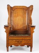 An interesting George III oak lambing-type chair, circa 1760 Having a flattened ogee-arched