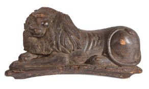 A large 18th century, or possibly earlier, carved pine and polychrome-decorated lion couchant
