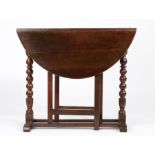 A Charles II walnut gateleg occasional table, circa 1680 Having an oval drop-leaf top, on ball-