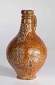 A 17th century bellarmine jug, German, probably Rhenish Of ovoid shape, with mottled tigerware