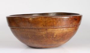 An exceptionally large late George III stained sycamore dairy bowl, circa 1820 With single incised