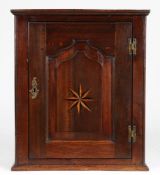 An interesting George III oak and inlaid mural cupboard, circa 1760 Having a fielded and flattened