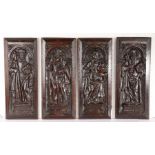 Four 16th century carved oak panels of Saints, circa 1530 Each standing beneath an arch, on a