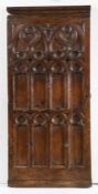 A 15th century oak pew end, circa 1450 Carved with oculi, mouchettes and tracery lights, rounded
