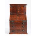 A George III elm miniature bureau cabinet, circa 1800-20 Having a pair of boarded doors, with