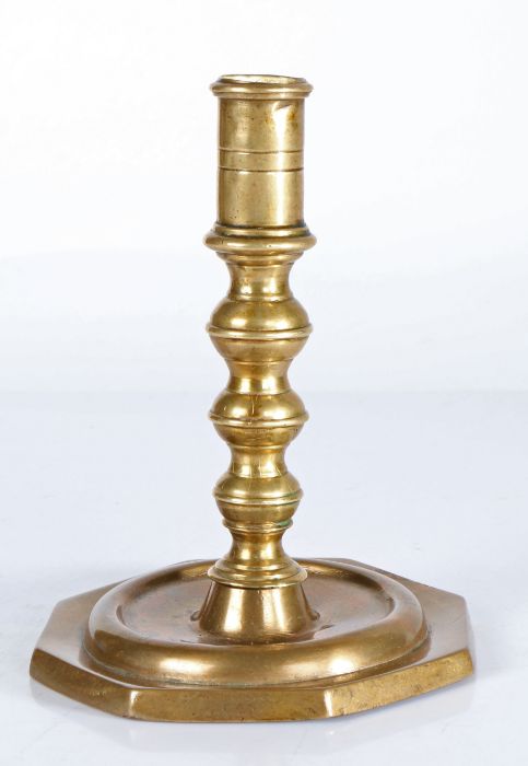 A late 17th century brass candlestick, Spanish With linear-incised cylindrical socket, the stem with