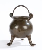 A small 15th/16th century bronze cauldron Having a spherical body, flared lip, and two mask handle