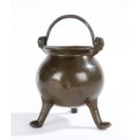 A small 15th/16th century bronze cauldron Having a spherical body, flared lip, and two mask handle