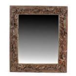 A late 19th century carved oak mirror The frame carved in high relief with meandering passion