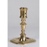 A late 17th century brass candlestick, Flemish The cylindrical socket with small circular extraction