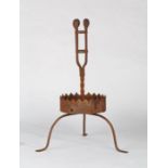 A wrought iron torchiere  Having a slender open 'basket', the side straps each with disc finial,