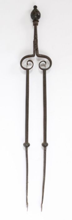 An interesting pair of late 17th century steel and bronze alloy fire tongs, English Topped by a