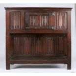 A mid-16th century oak linenfold standing cupboard, circa 1550 Having a boarded top with applied