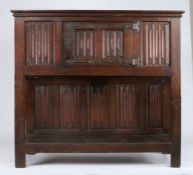A mid-16th century oak linenfold standing cupboard, circa 1550 Having a boarded top with applied