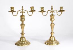 A pair of  mid-18th century brass candelabra, French, circa 1760 In the Rococo manner, each with a