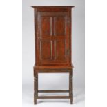 A Charles II oak and inlaid cupboard, circa 1670 The single door with four panels, each linear-