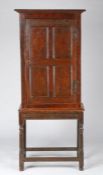 A Charles II oak and inlaid cupboard, circa 1670 The single door with four panels, each linear-