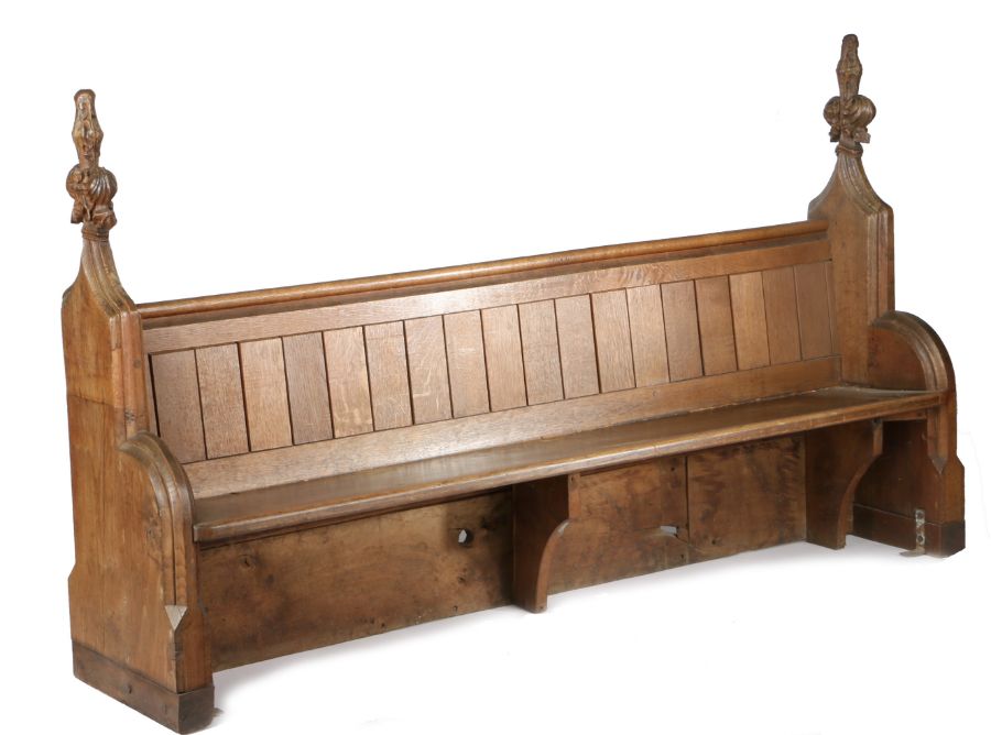 A pair of 15th century oak poppy-head pew ends, incorporated into a Victorian pew The boarded back