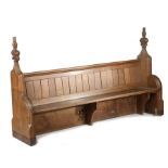 A pair of 15th century oak poppy-head pew ends, incorporated into a Victorian pew The boarded back