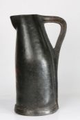 A good and large early 17th century leather bombard, English, circa 1600-50 With typical stitched