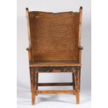 A late 19th century pine and black oat-straw Orkney chair Having a broad and curved/winged lip-
