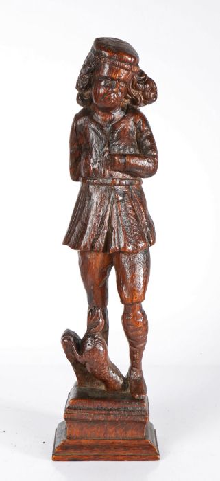 A 16th century carved oak figure of St. Roche Designed standing, with flat cap and shoulder-length