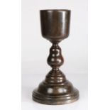 A stained fruitwood standing cup, probably English and circa 1700 The U-shaped bowl supported on