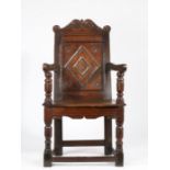 A Charles I oak panel-back open armchair, Gloucestershire, circa 1630 With prominent raked back, the