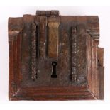 A 16th century iron lock Mounted on a mitre-moulded oak frame, with one key-hole, and two hasps, one