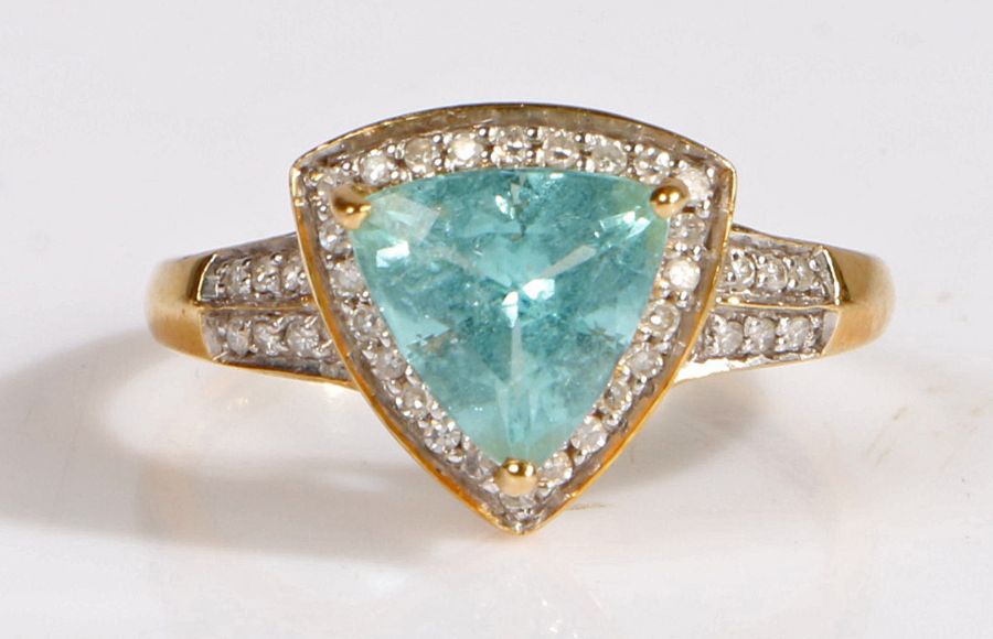 A 18 carat gold paraiba tourmaline and diamond ring, the head set with a claw mounted triangular cut